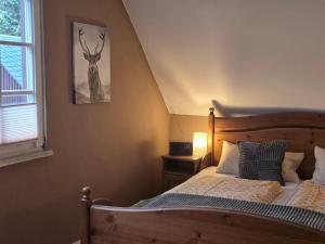 a bedroom with a bed with a deer picture on the wall at Huthaus zum Molchner Stollen in Pobershau