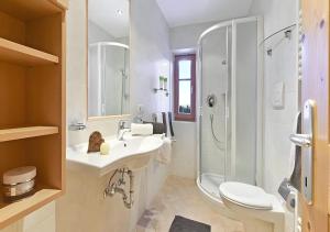 a white bathroom with a sink and a shower at Appartments Radauerhof in Castelrotto +20 photos
