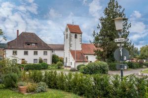a white building with a clock tower in a garden at Ferienwohnung Schweizer in Gaienhofen