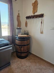 a kitchen with a wine barrel in the corner of a room at Casa vico roma Rosanto in Orosei