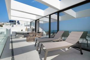 a living room with chairs and a table on a balcony at Suite Horizonte in Puerto del Carmen