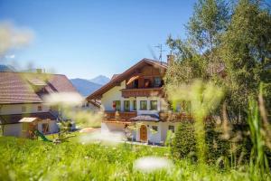 a house in the middle of a field of grass at Haus zur Vogelweide App 6 in Dobbiaco