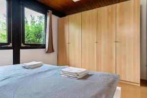 a bedroom with a bed with wooden cabinets and a window at Bungalow Nordschwarzwald in Schellbronn