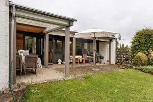 a patio with an umbrella and a table and chairs at Bungalow Nordschwarzwald in Schellbronn