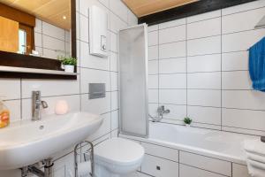 a bathroom with a sink and a toilet and a mirror at Bungalow Nordschwarzwald in Schellbronn +16 photos
