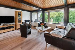 a living room with a couch and a tv at Bungalow Nordschwarzwald in Schellbronn
