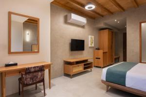 a bedroom with a bed and a desk and a mirror at Olive Woods in Chinnakanal