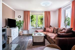 a living room with a couch and a tv at Ferienwohnung am Elbstrom in Stade