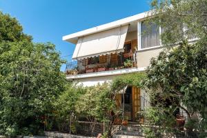 an apartment building with a balcony and trees at Makis Apartment Katelios in Khionáta
