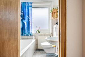 a bathroom with a tub and a toilet and a sink at Ferienwohnung am Elbstrom in Stade +14 photos