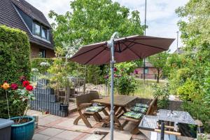 a patio with an umbrella and a table and chairs at Ferienwohnung am Elbstrom in Stade