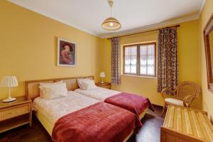 a hotel room with two beds and a window at Cottage Sete Mares in Colares +23 photos