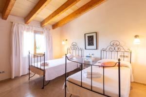 a bedroom with two beds and a window at Finca Son Fornes in Búger +27 photos