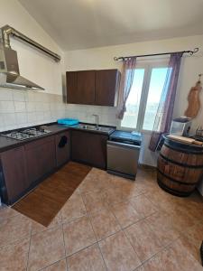 a kitchen with a sink and a stove and a window at Casa vico roma Rosanto in Orosei
