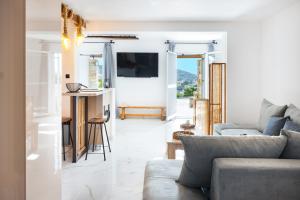 a living room with a couch and a tv at Mont' Rock villas 1 in Posidhonía