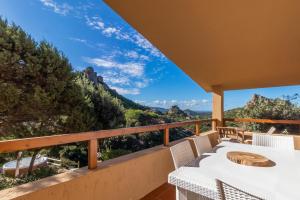 a balcony with a table and chairs and mountains at Villa Aloe 2 in Costa Paradiso