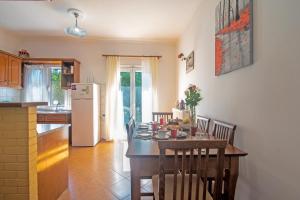 a kitchen with a table with chairs and a refrigerator at Kallithea House in Corfu
