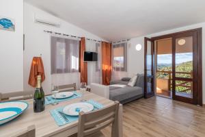 a living room with a dining table and a bedroom at Villa Aloe 2 in Costa Paradiso