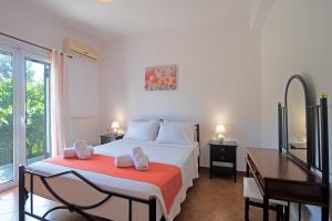 a bedroom with a bed with two chairs and a desk at Kallithea House in Corfu