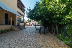 a cobblestone street with chairs and trees and a building at Kallithea House in Corfu