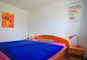 a bedroom with a bed with a blue blanket at Blauer Bungalow am See mit Boot in Klein Labenz