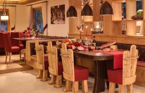 a kitchen with a wooden table with chairs and a dining room at Alpenhof Lodge Hirzer in Saltusio