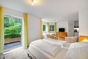 a bedroom with two beds and a large window at Ferienapartment Remke in Starnberg