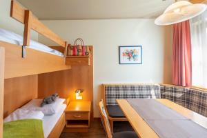 a bedroom with a bunk bed and a table at Alpenhof Lodge Hirzer in Saltusio +12 photos