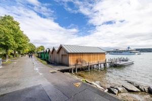 a building next to the water with a cruise ship at Ferienapartment Remke in Starnberg