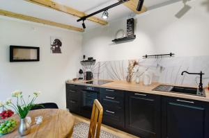 a kitchen with black cabinets and a wooden table at Ferienwohnung Seelenruhig in Wollershausen