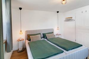 a bedroom with a large bed with green sheets at Ferienwohnung Seelenruhig in Wollershausen