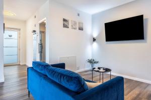 a living room with a blue couch and a tv at Egge Resort 7d mit Whirpool u Sauna in Altenbeken