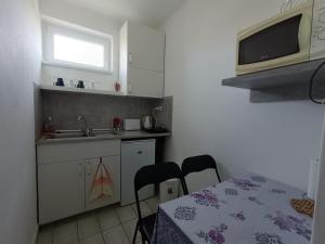 a small kitchen with a table and a microwave at Herőke Vendégház in Terény