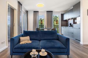 a living room with a blue couch and a kitchen at Egge Resort 7d mit Whirpool u Sauna in Altenbeken