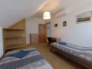 a bedroom with two beds and a desk and a desk at Herőke Vendégház in Terény