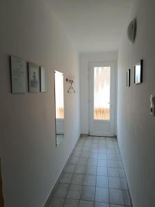 a hallway with a door and a tiled floor at Herőke Vendégház in Terény