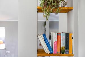 a row of books on a book shelf at Ferienwohnung an der Schlei oben in Fleckeby