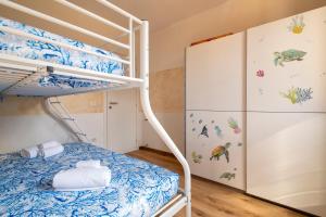 a bedroom with a bunk bed and a refrigerator at Holiday Cala Sant'andrea in Stintino