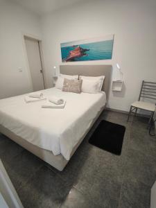 a bedroom with a large white bed and a chair at Funchal House in Funchal