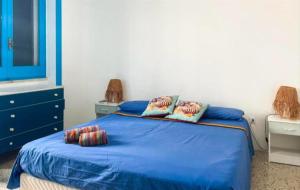 a bedroom with a blue bed with two pillows at Mediterranea in Torre Pali