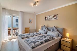 a bedroom with a bed and a balcony at Ferienwohnungen Meyer in Hochbuch
