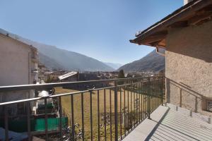 a balcony with a view of a town and mountains at Casa Ronden Mortirolo in Mazzo di Valtellina