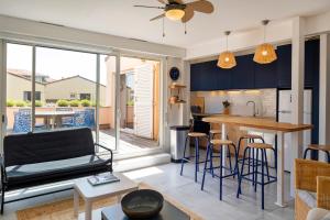 a kitchen and living room with blue cabinets at Appartement Notre Dame in Capbreton