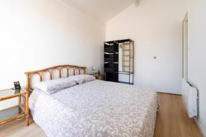 a bedroom with a bed in a white room at Appartement Notre Dame in Capbreton