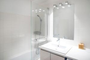 a white bathroom with a sink and a shower at Appartement Notre Dame in Capbreton +22 photos