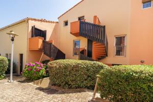 a building with stairs and bushes in front of it at Appartement Notre Dame in Capbreton