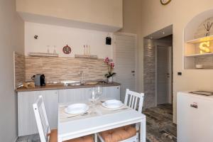 a kitchen with a table with two plates on it at Sg Apartment Luxury in Massafra +12 photos