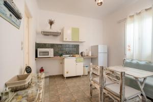 a small kitchen with a table and a refrigerator at Green Retreats 1 Paros in Isterni +14 photos