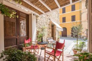 a patio with red chairs and a table on a patio at Radicondoli Studio in Radicondoli