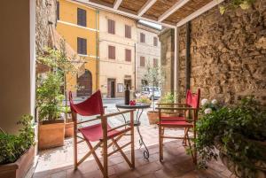 a patio with two chairs and a table on a courtyard at Radicondoli Studio in Radicondoli +18 photos